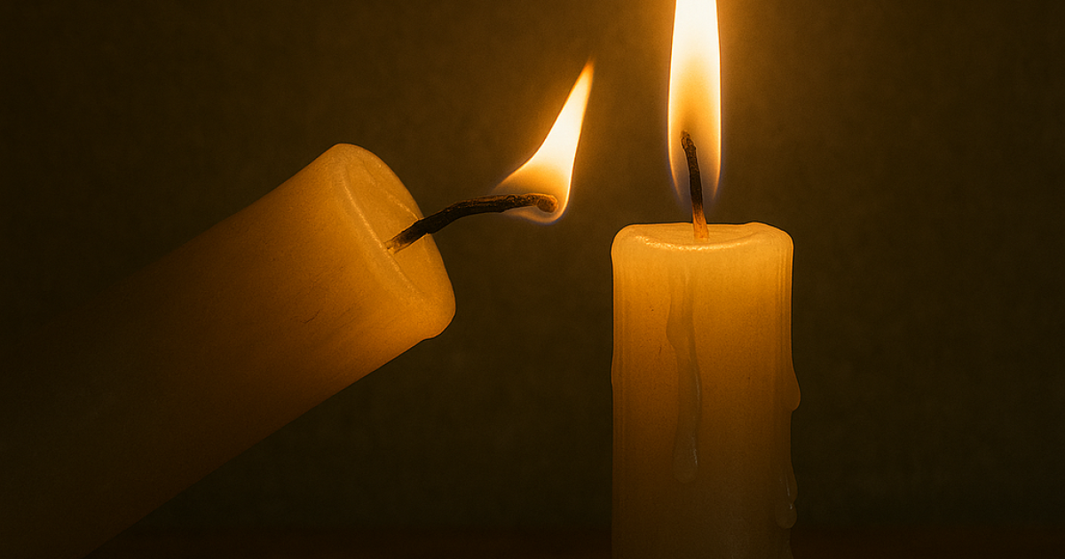 A lit candle leans toward an unlit one, transferring its flame. The act symbolizes how generosity and goodness can be shared without being diminished.